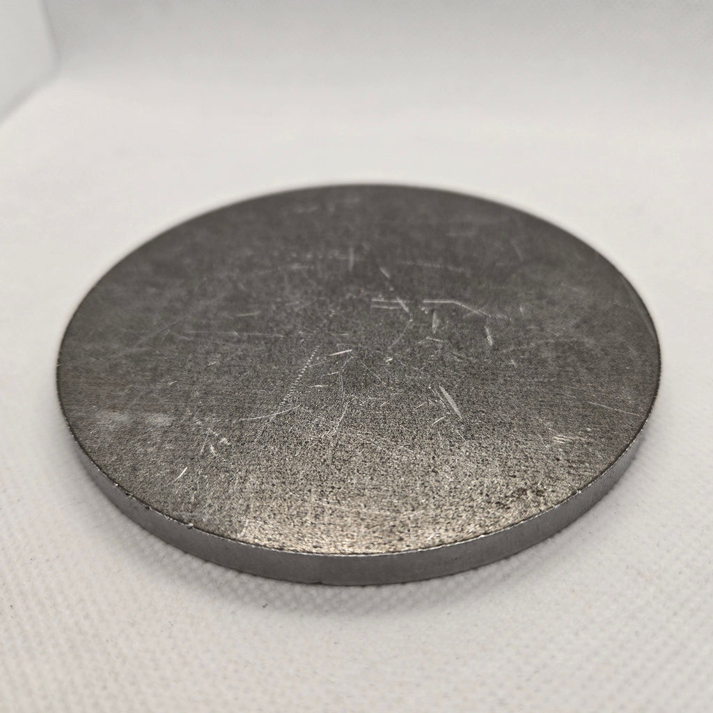 Metallic disc on a textured white surface